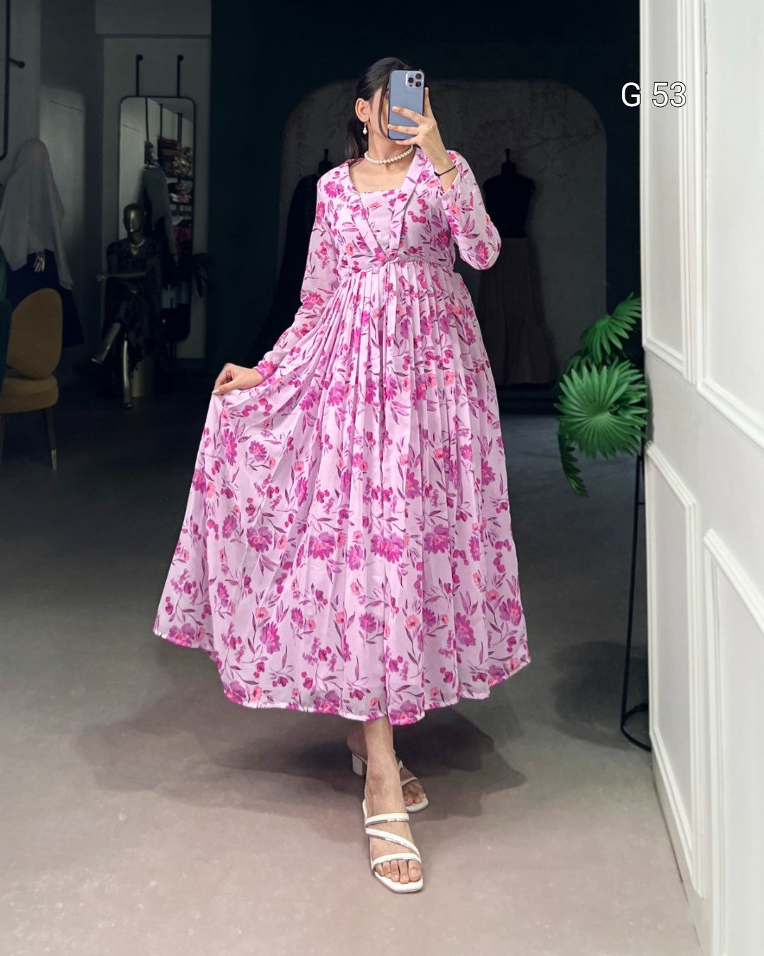 Person wearing a pink floral dress in a room with a mirror and chair.