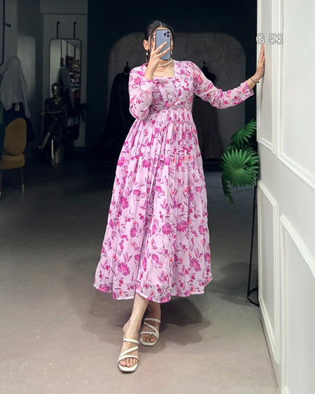 Person wearing a pink floral dress taking a mirror selfie in a room.