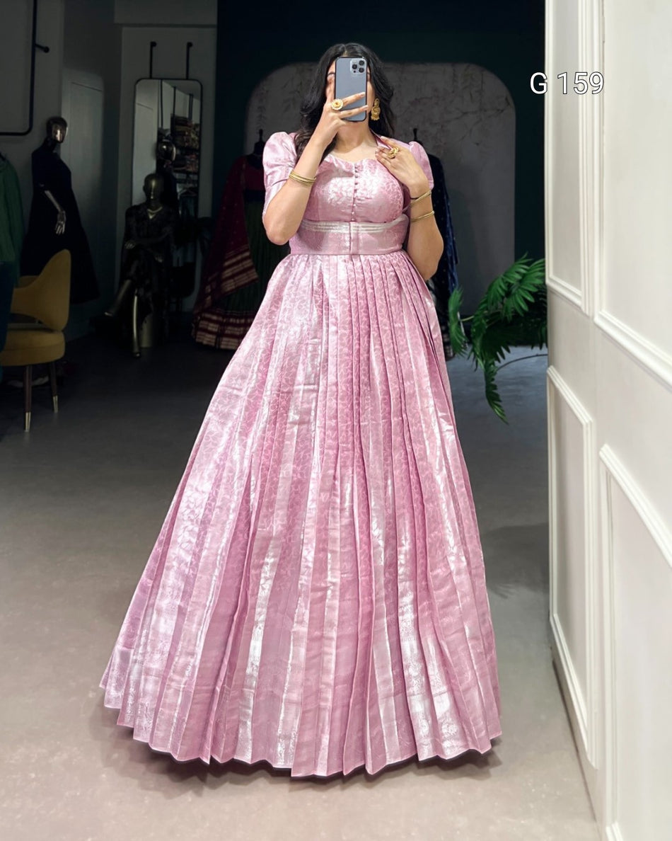 Person wearing a pink pleated dress in an indoor setting.