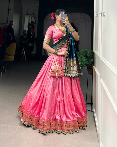 Person wearing a traditional pink and blue saree with gold details indoors.