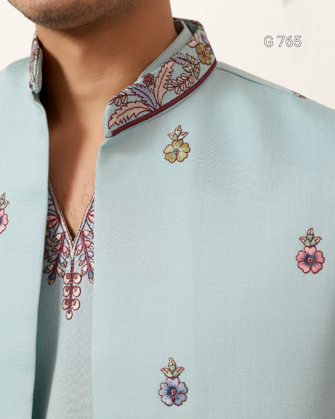 Light blue shirt with floral embroidery on a plain background