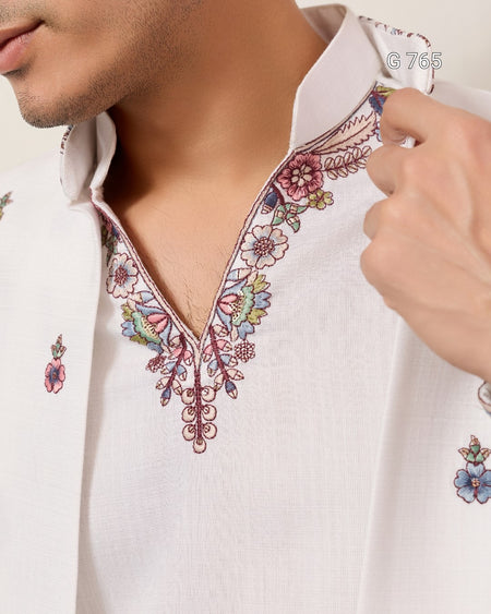 Close-up of a white shirt with floral embroidery on a plain background