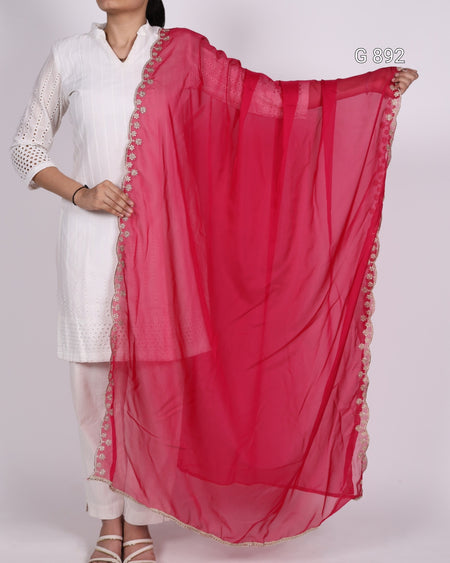 Person wearing a white outfit with a red dupatta draped over one shoulder on a white background