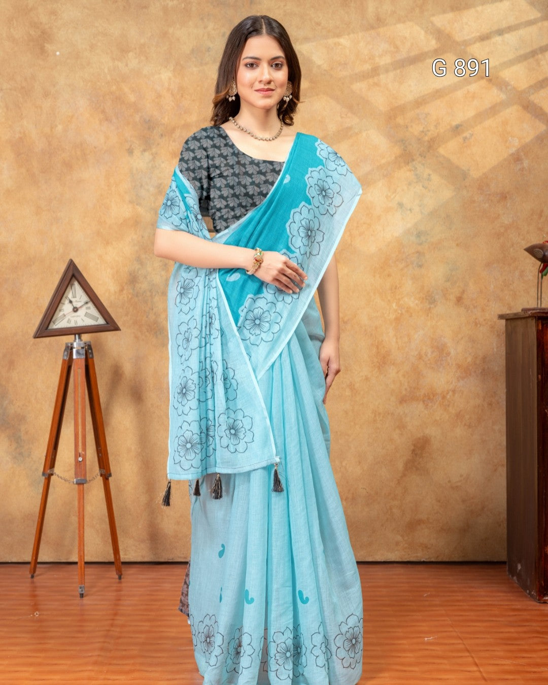 Woman wearing a light blue saree with a brown background