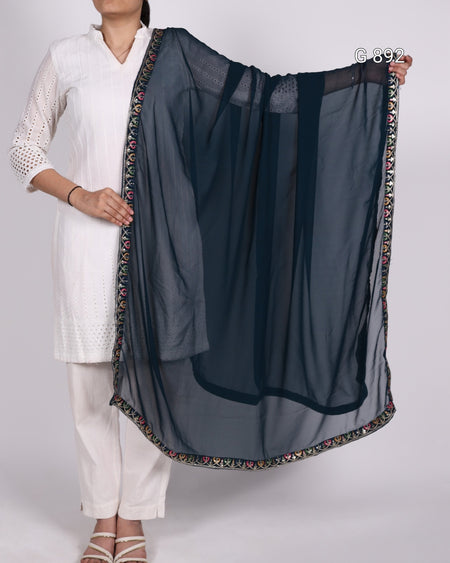 Person holding a dark blue dupatta with a colorful border on a white background