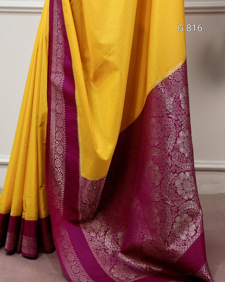 Yellow saree with purple border on a neutral background