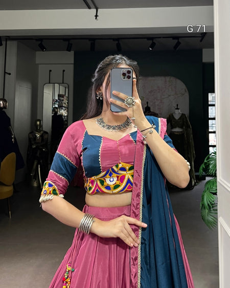 Person wearing a colorful traditional outfit with a patterned top and pink skirt in a store setting.