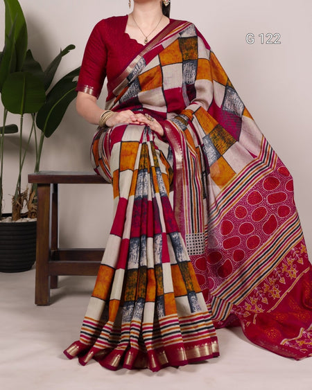 Woman wearing a colorful saree with a patterned design, sitting on a wooden stool.