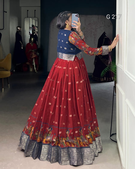 Woman taking a mirror selfie wearing a traditional red and blue outfit with intricate patterns.