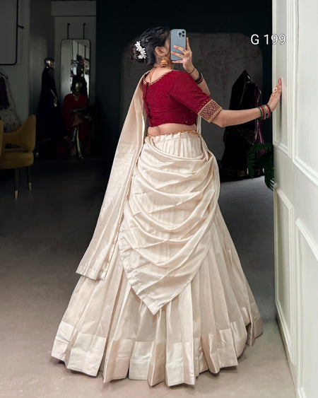 Woman taking a mirror selfie wearing a red blouse and white saree.