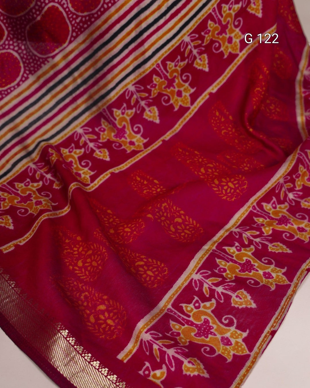 Red fabric with gold and yellow patterns on a white background