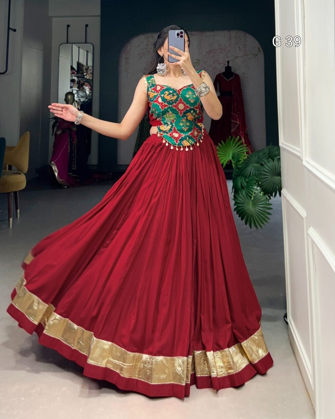 Red traditional outfit with gold details worn by a person in a room.