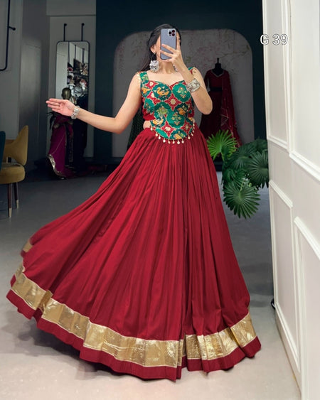 Red traditional outfit with gold details worn by a person in a room.