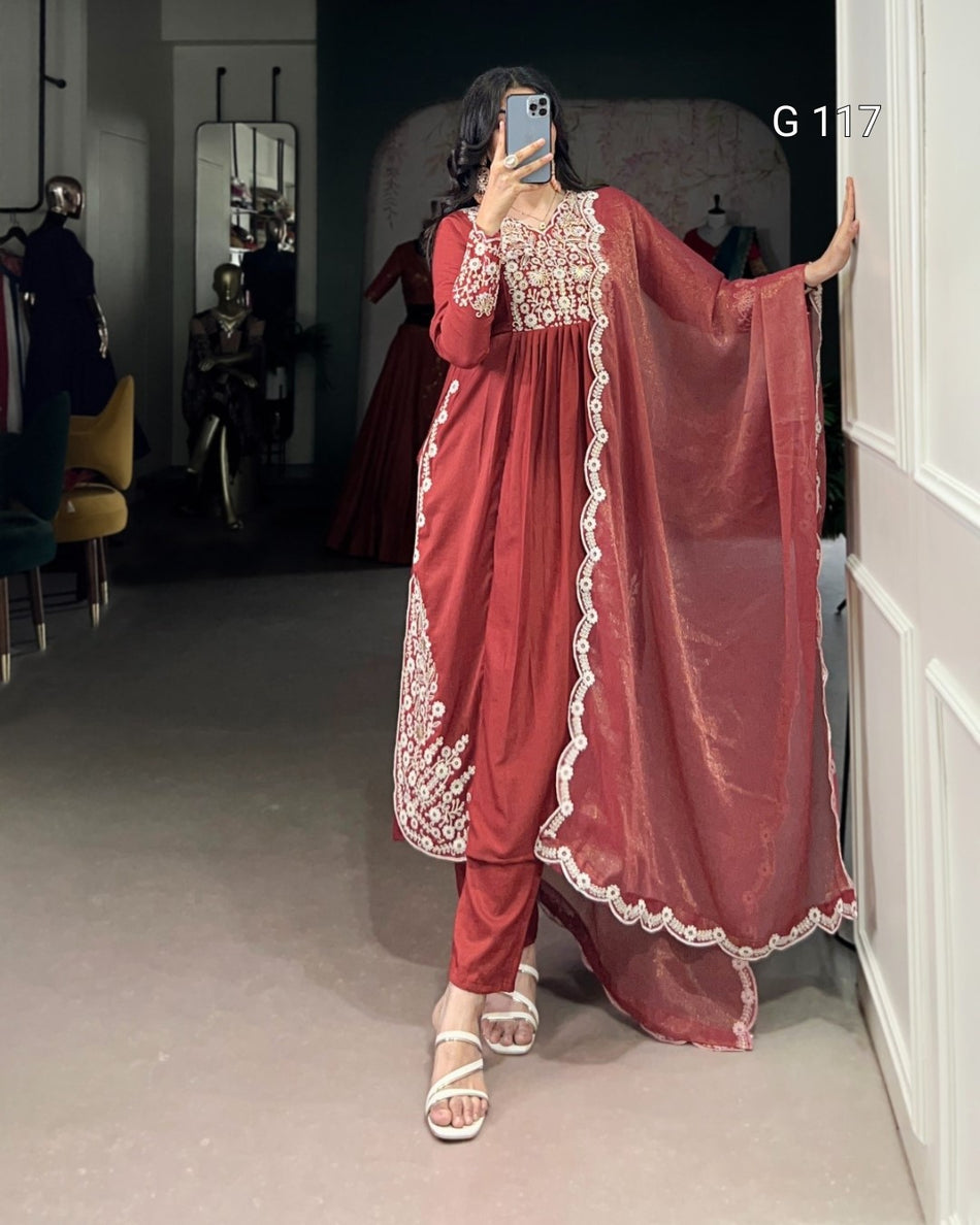 Person wearing a traditional red outfit with white embroidery in a room.