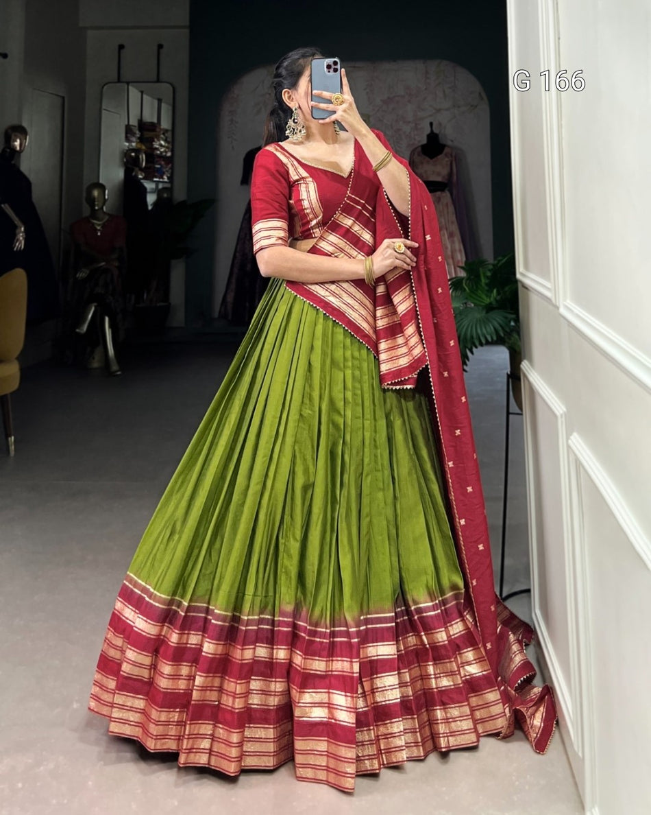 Woman wearing a green and red traditional outfit in a room.