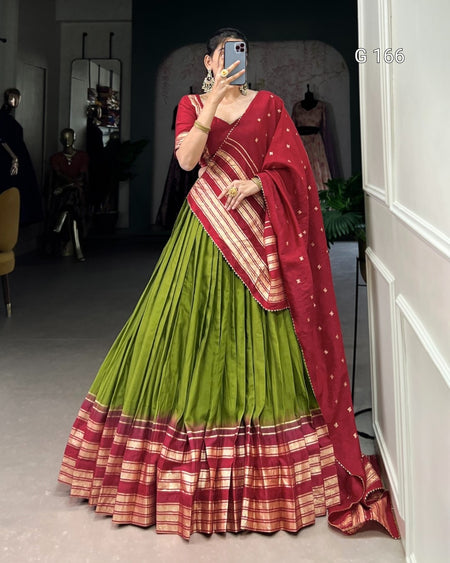 Person wearing a traditional outfit with a red and green saree in a mirror selfie.