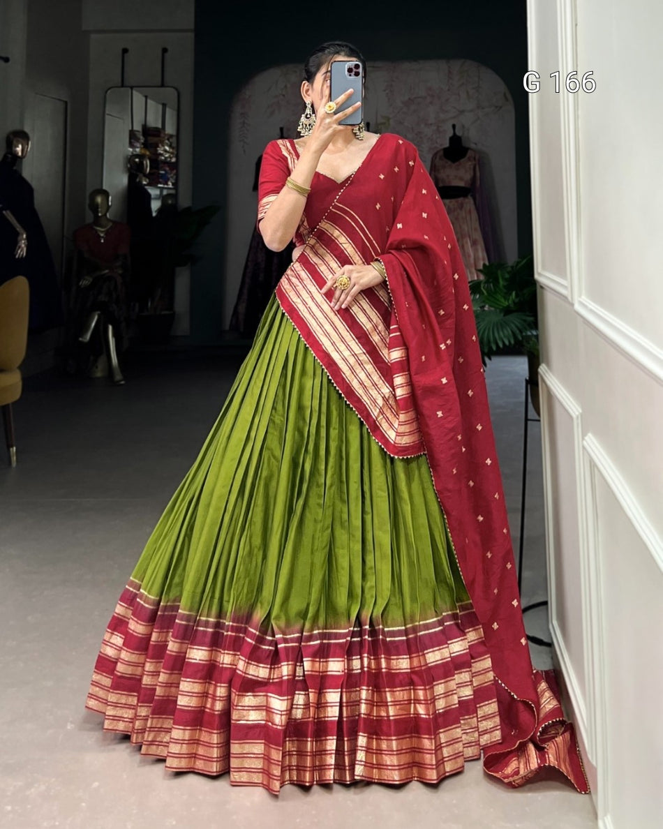 Person wearing a traditional outfit with a red and green saree in a mirror selfie.