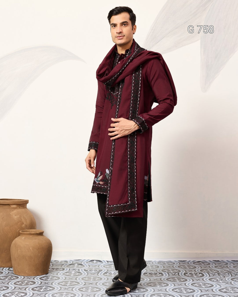 Man wearing a maroon traditional outfit with a scarf against a white background
