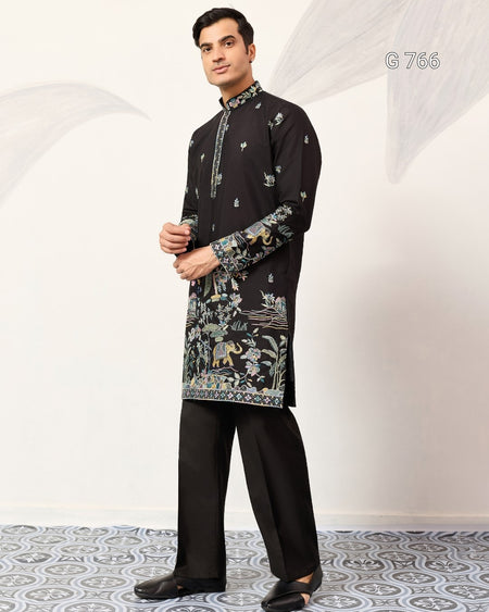 Man wearing a black kurta with intricate patterns on a white background