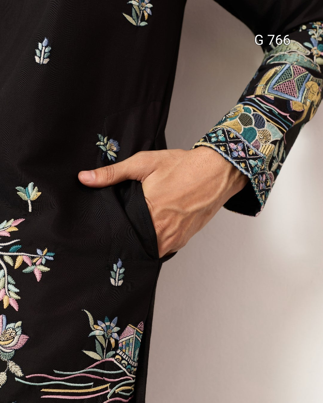Black garment with colorful floral embroidery on a plain background