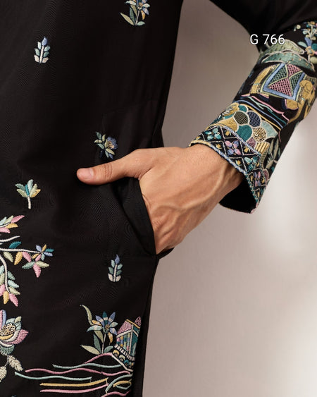 Black garment with colorful floral embroidery on a plain background