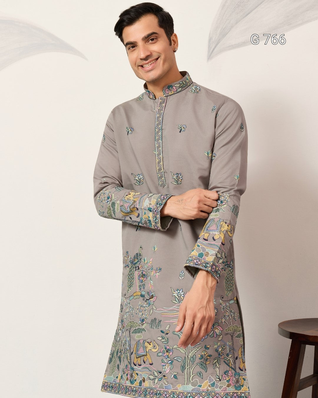 Man wearing a gray embroidered kurta against a white background