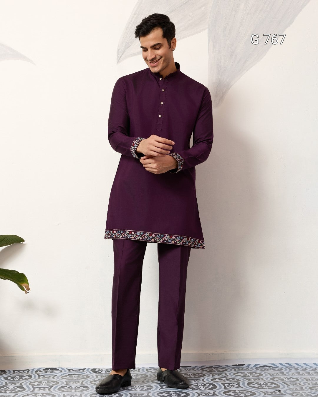 Man wearing a purple traditional outfit with a white background