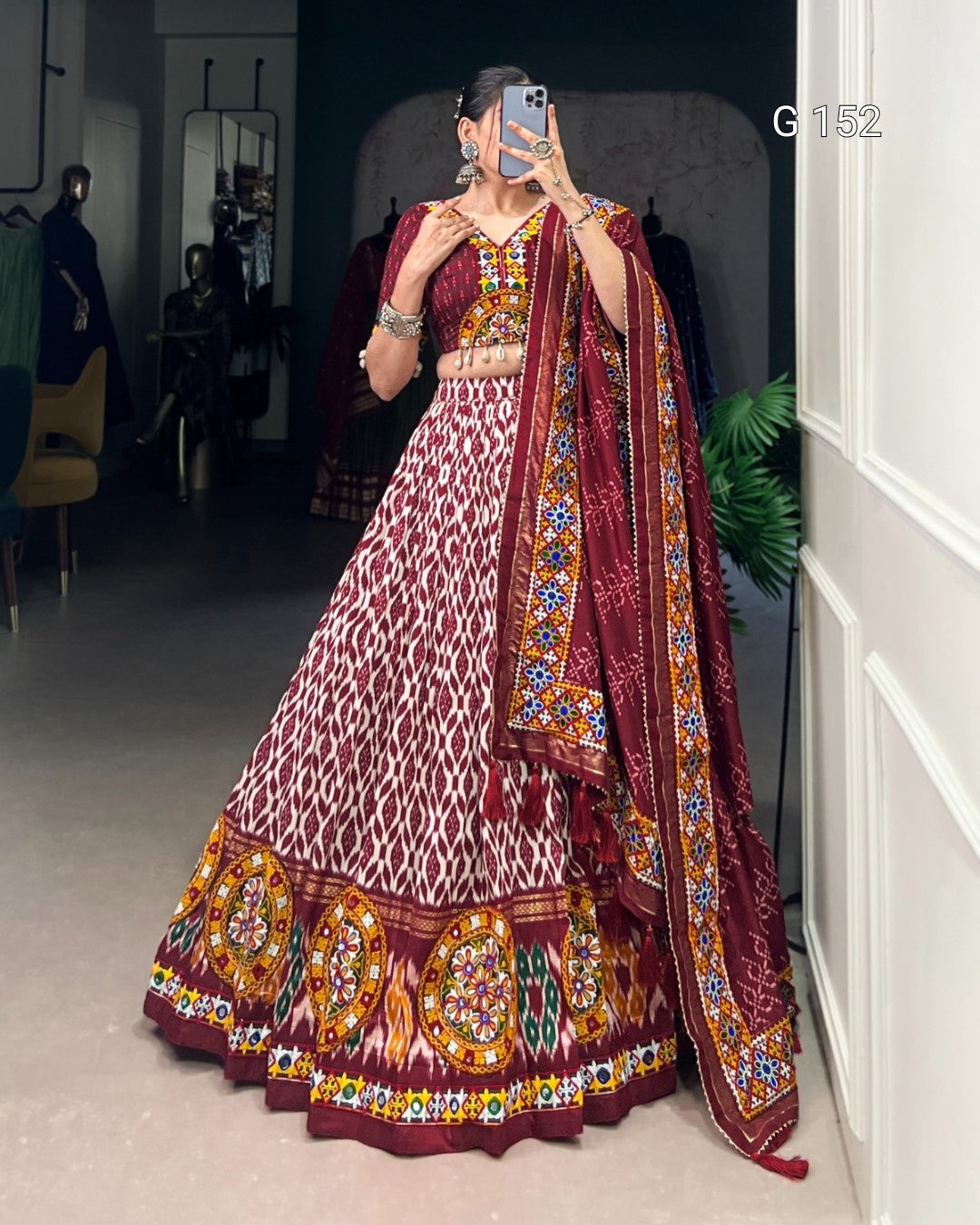 Person wearing a traditional maroon and gold embroidered outfit with a matching dupatta.