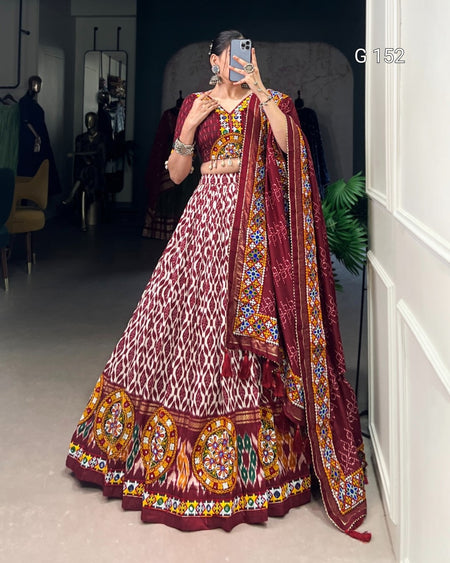 Person wearing a traditional maroon and gold embroidered outfit with a matching dupatta.