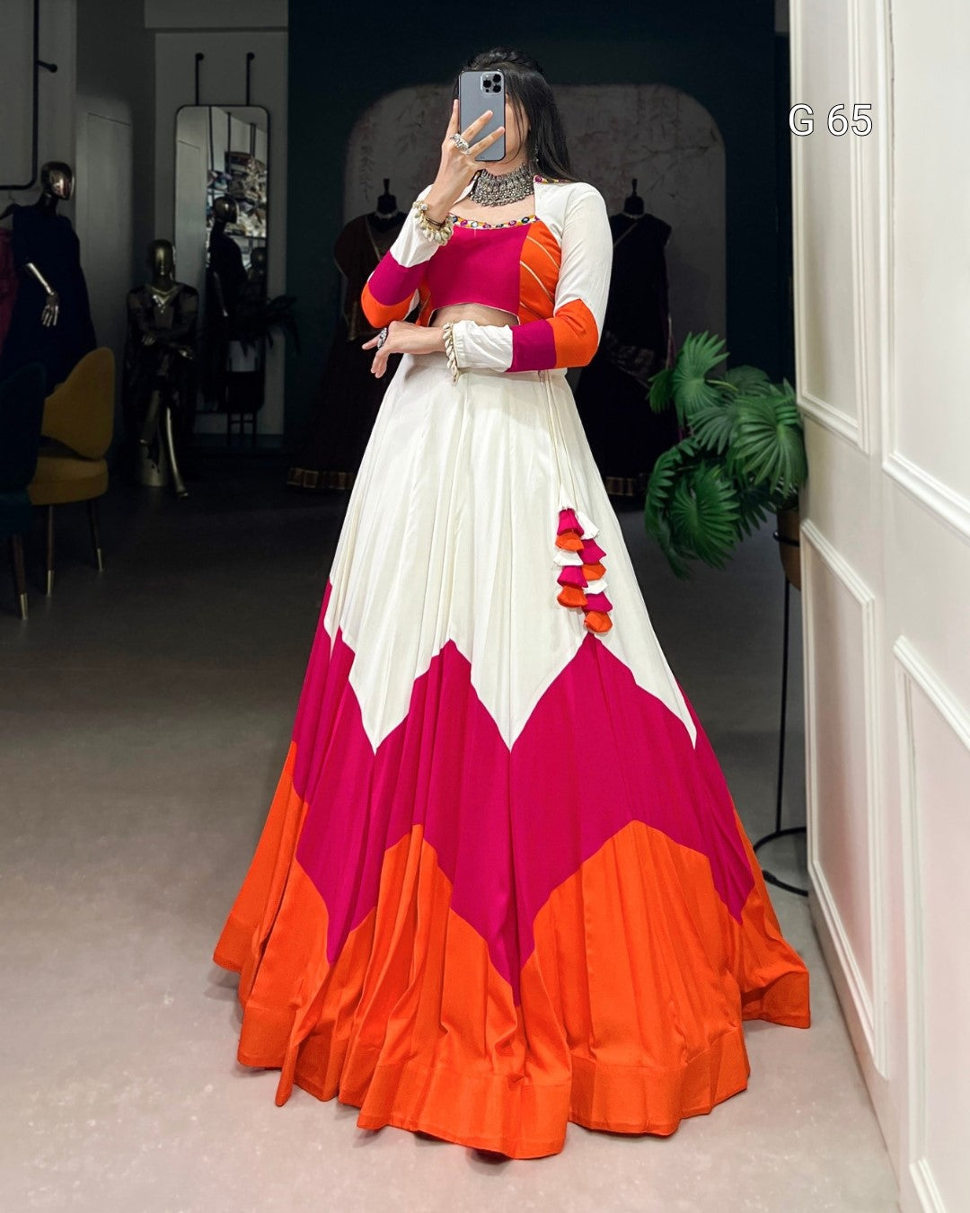 Person wearing a colorful dress with pink and orange design in a room.