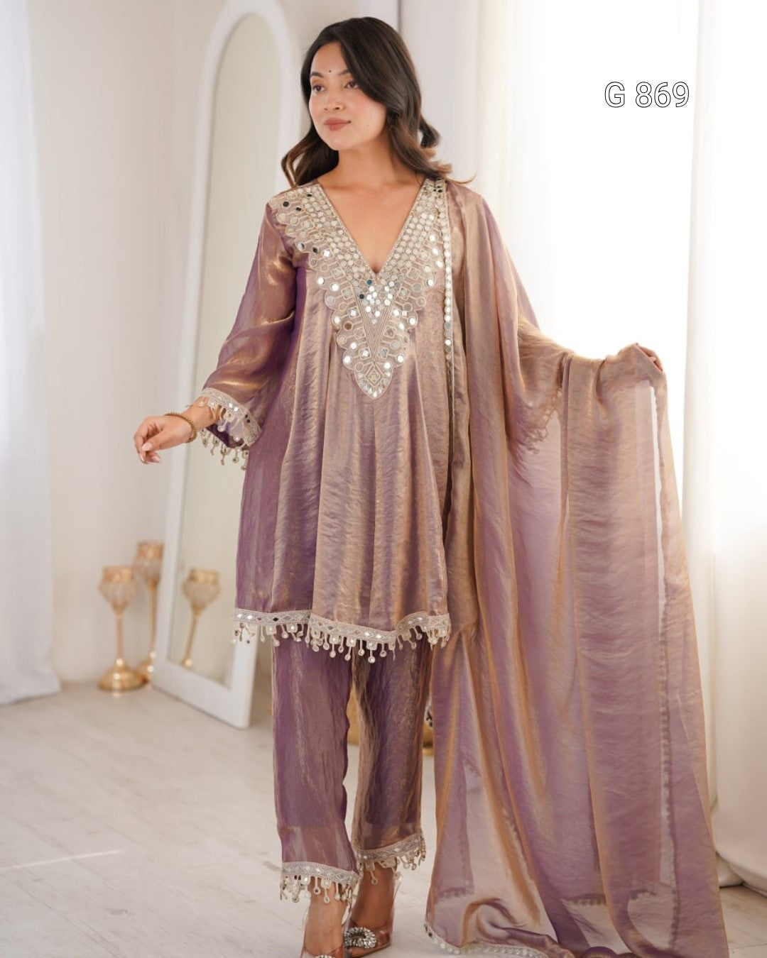 Woman wearing a traditional outfit with a shawl in a well-lit room.