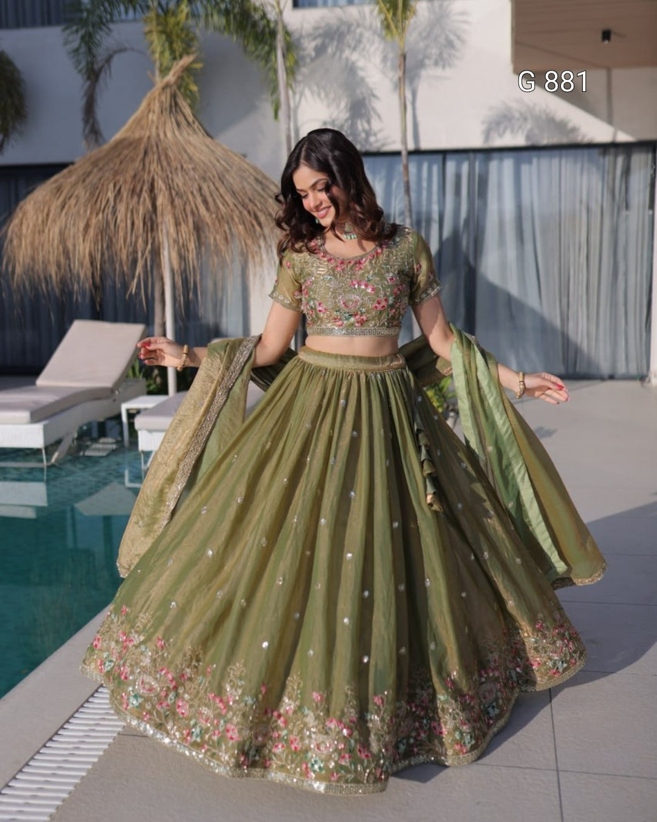 Woman in a green traditional outfit standing by a poolside.