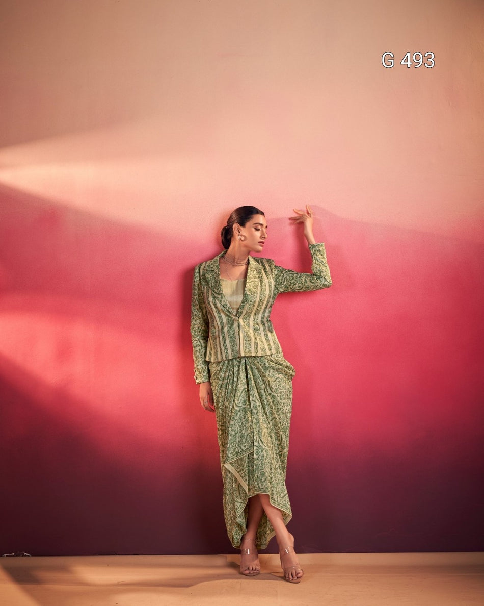 Woman in a green patterned outfit standing against a pink and purple gradient wall.