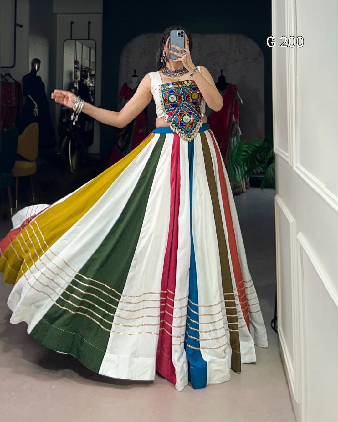 Woman wearing a colorful traditional dress with a multicolored skirt in a room.