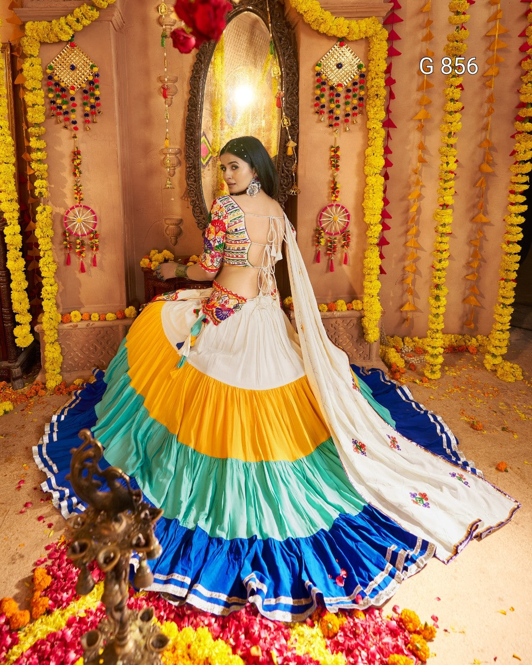 Woman in a colorful traditional outfit with a decorated background