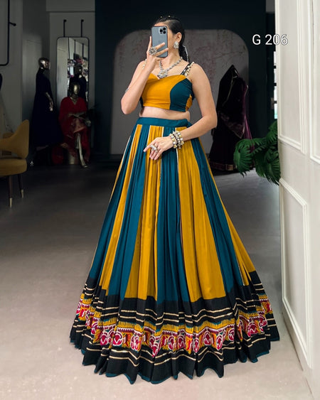 Woman wearing a colorful traditional outfit with a patterned skirt in a room.