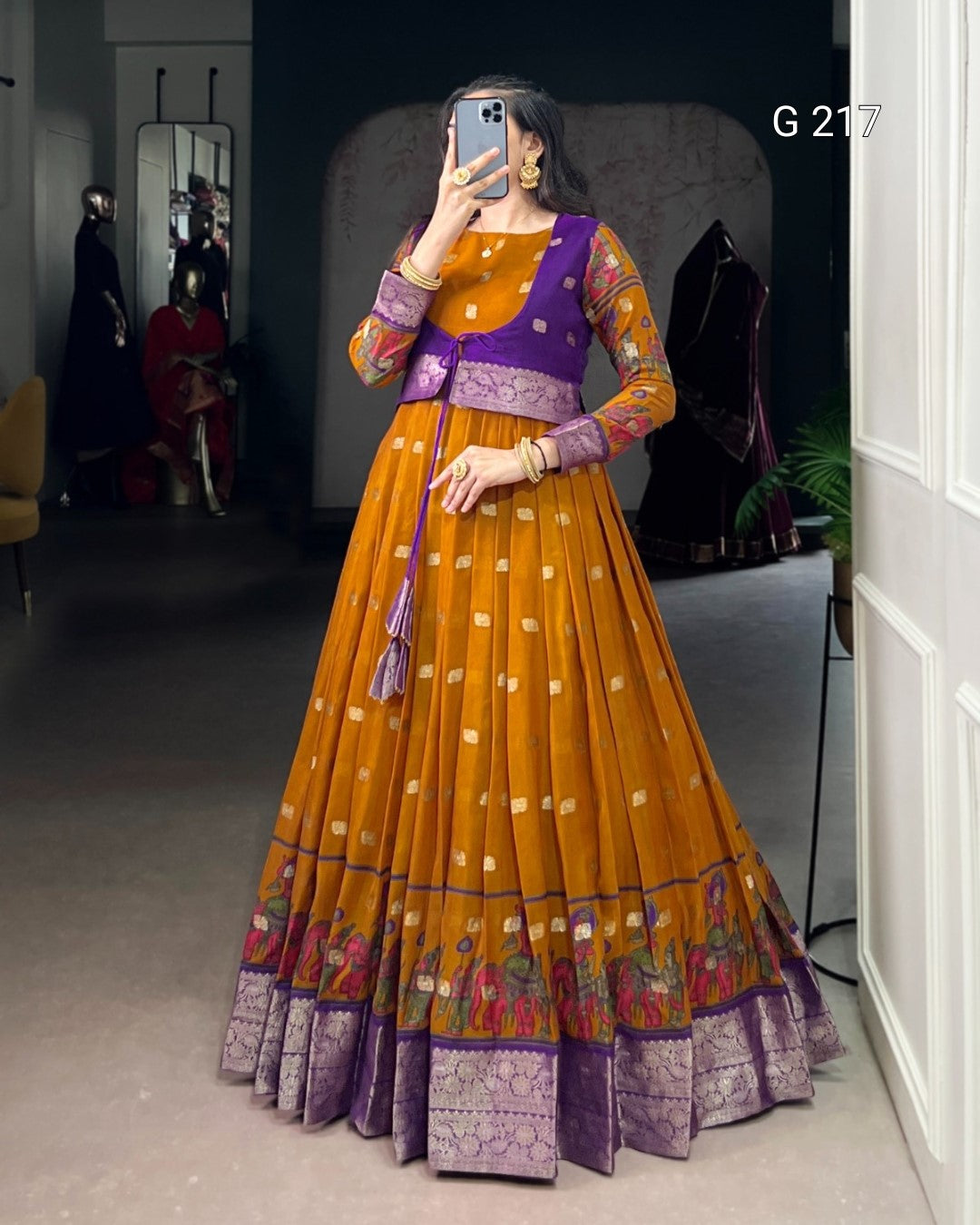 Person wearing a traditional outfit with a purple top and orange skirt in a room.