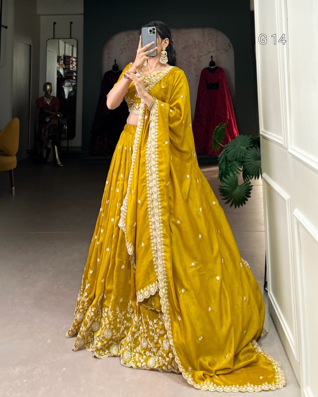 Person wearing a yellow traditional outfit with a matching dupatta, standing in a room.