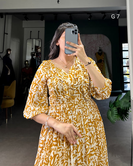 Person wearing a yellow patterned dress taking a mirror selfie.