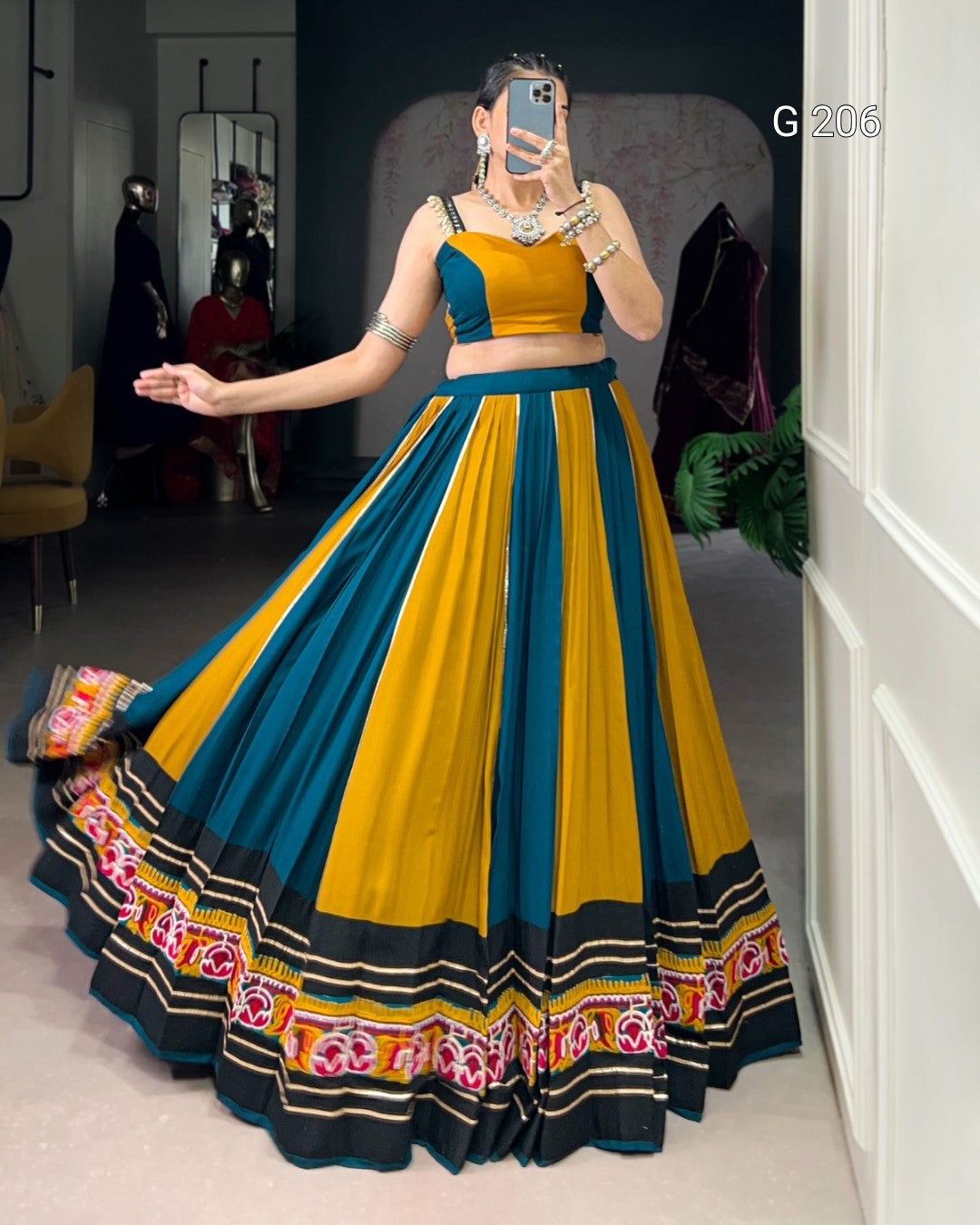 Woman wearing a colorful traditional outfit with a long skirt in a room.