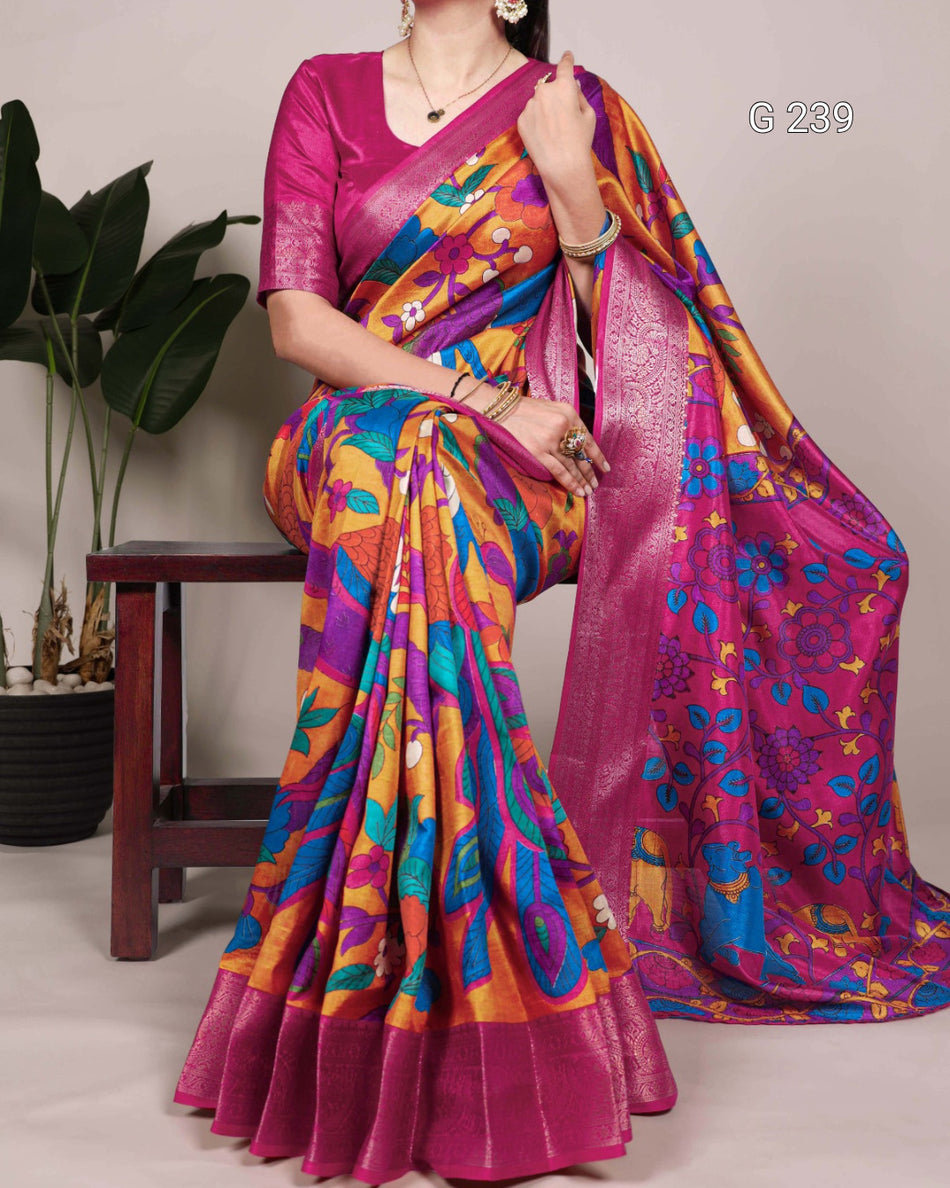 Woman wearing a colorful saree with a pink blouse, sitting on a chair.