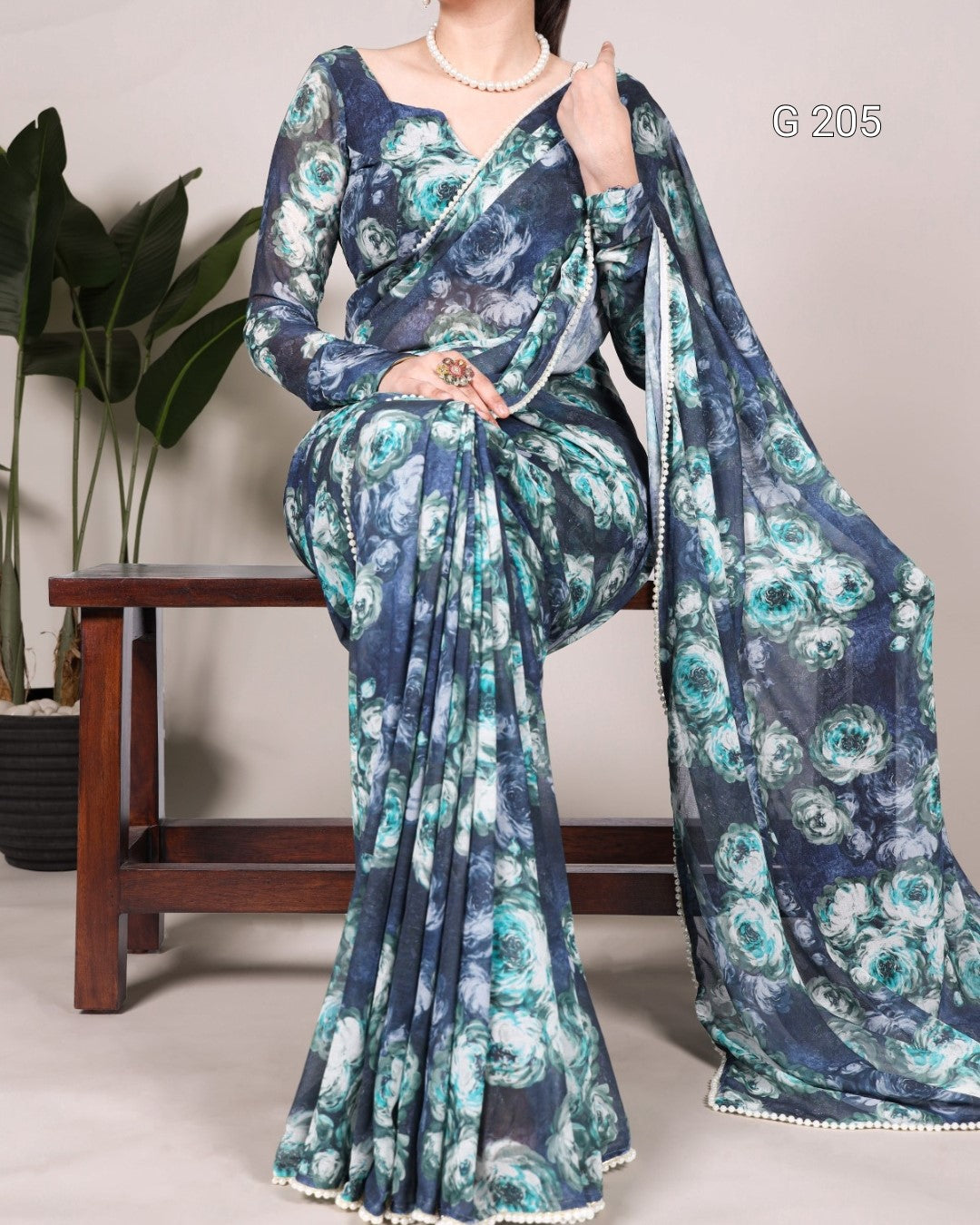 Blue floral saree with matching blouse on a neutral background