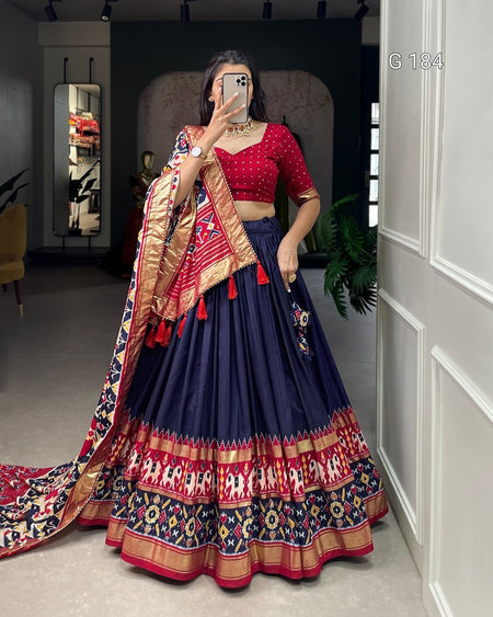 Woman in a traditional outfit with a colorful dupatta taking a mirror selfie.