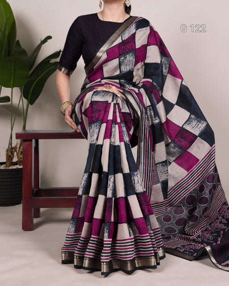Person wearing a patterned saree with a plant in the background