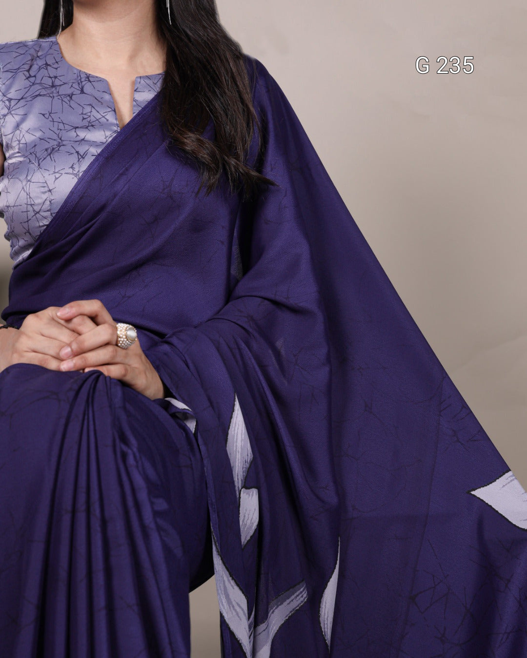 Woman wearing a purple saree with a plain background