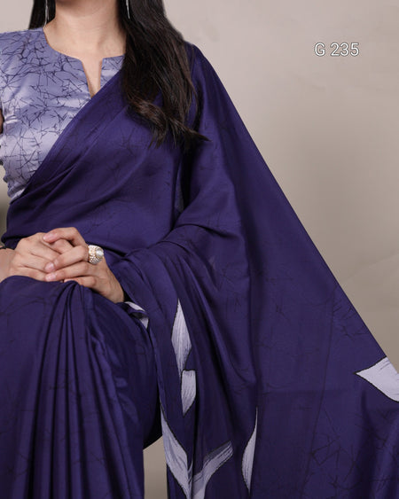 Woman wearing a purple saree with a plain background