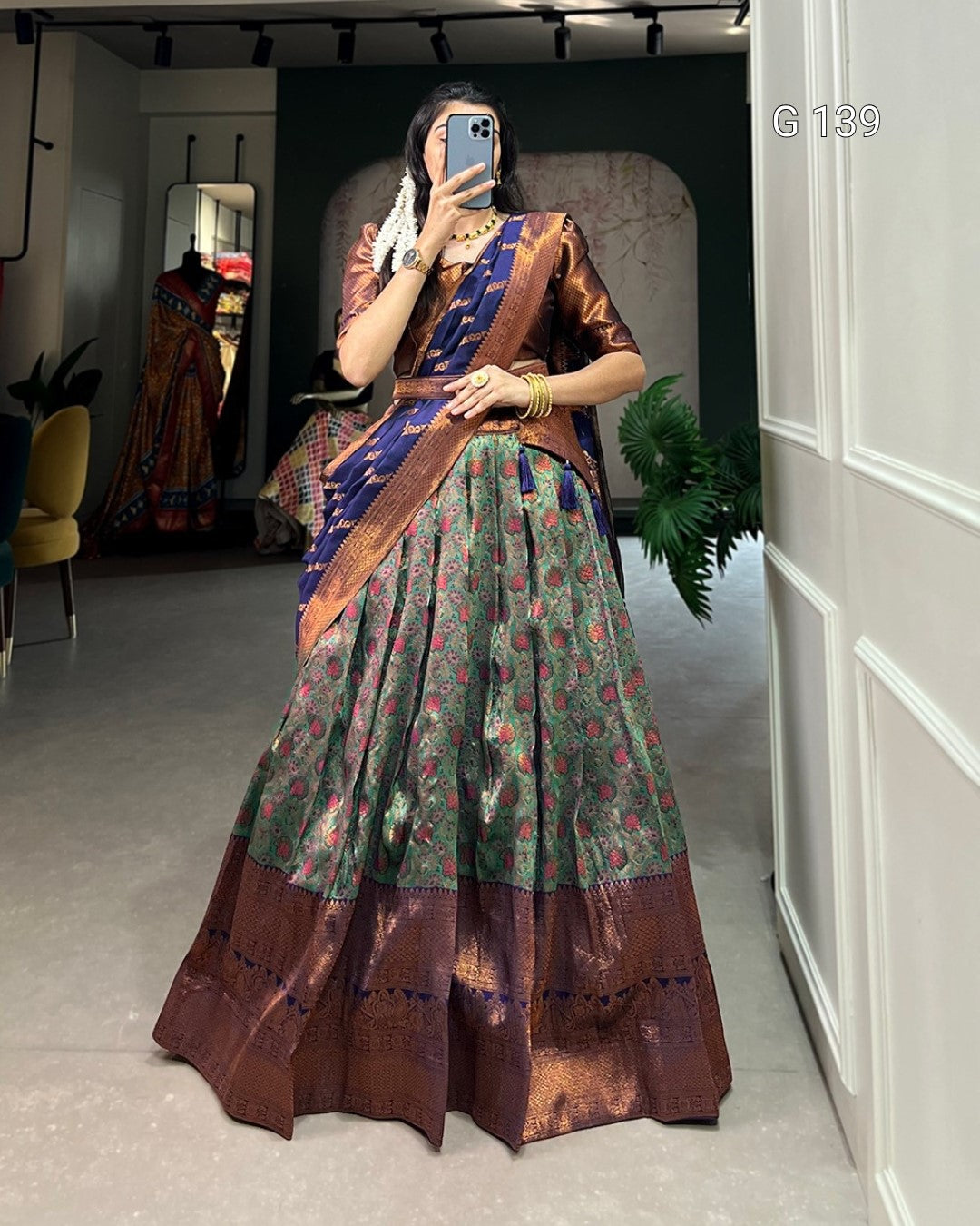 Person wearing a traditional saree in a room with decor elements.
