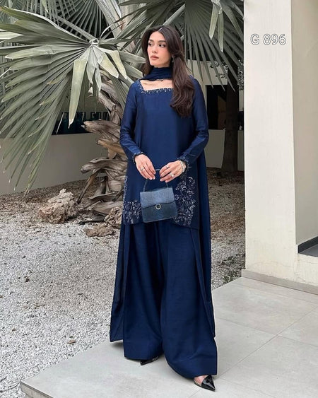 Woman in a blue dress standing outdoors with decorative elements.