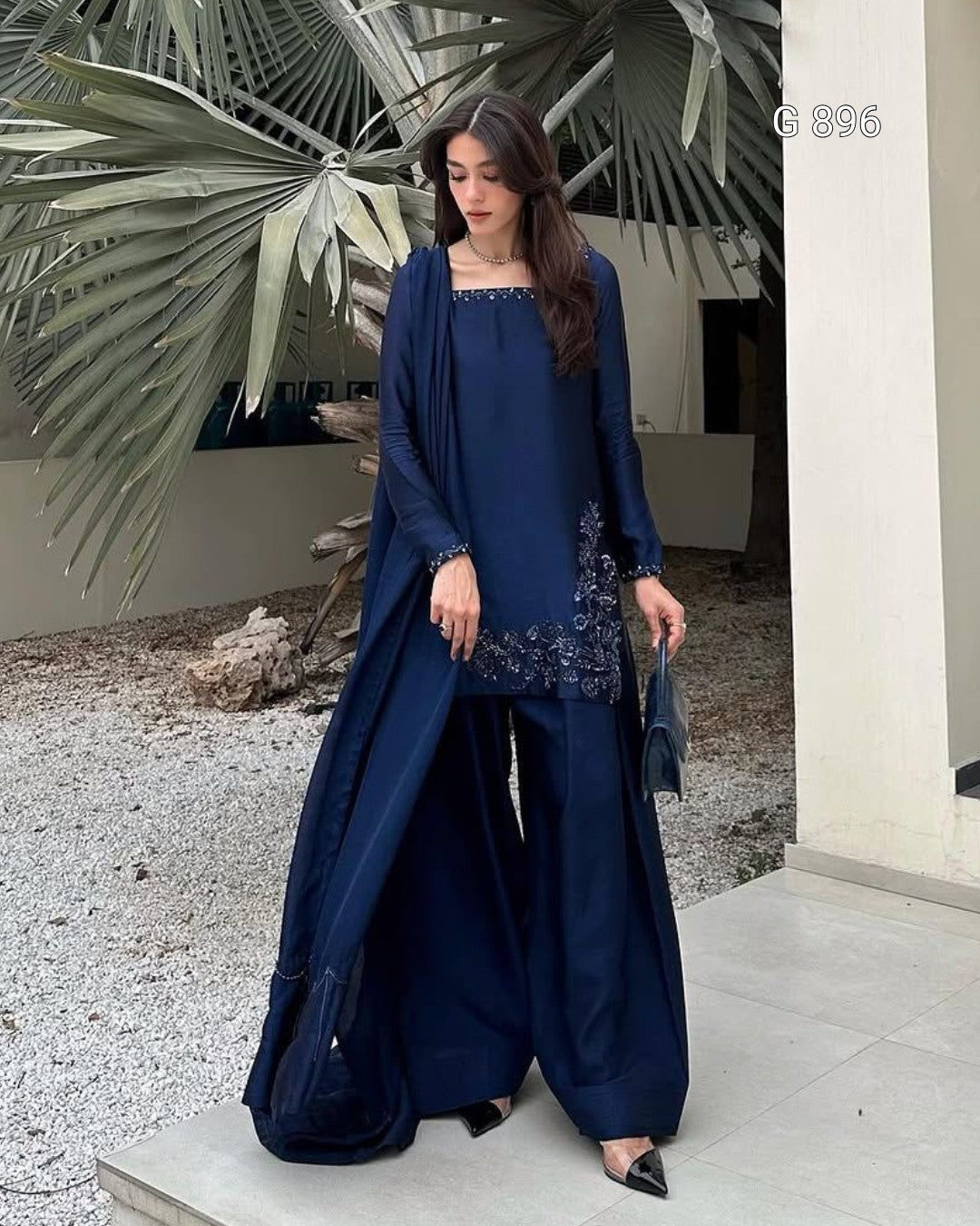 Woman in a blue outfit standing outdoors with decorative elements.