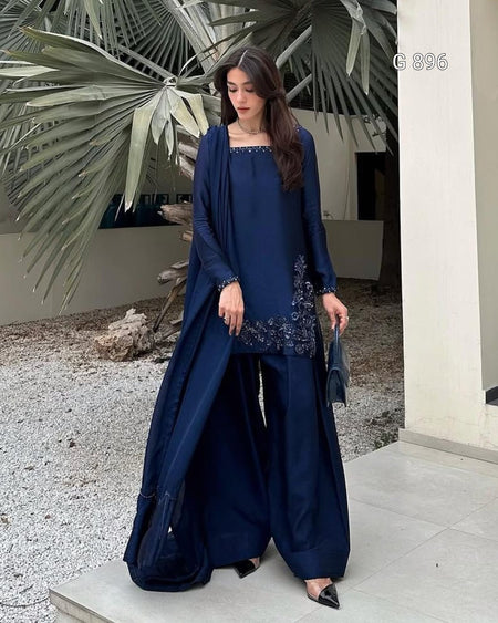 Woman in a blue outfit standing outdoors with decorative elements.